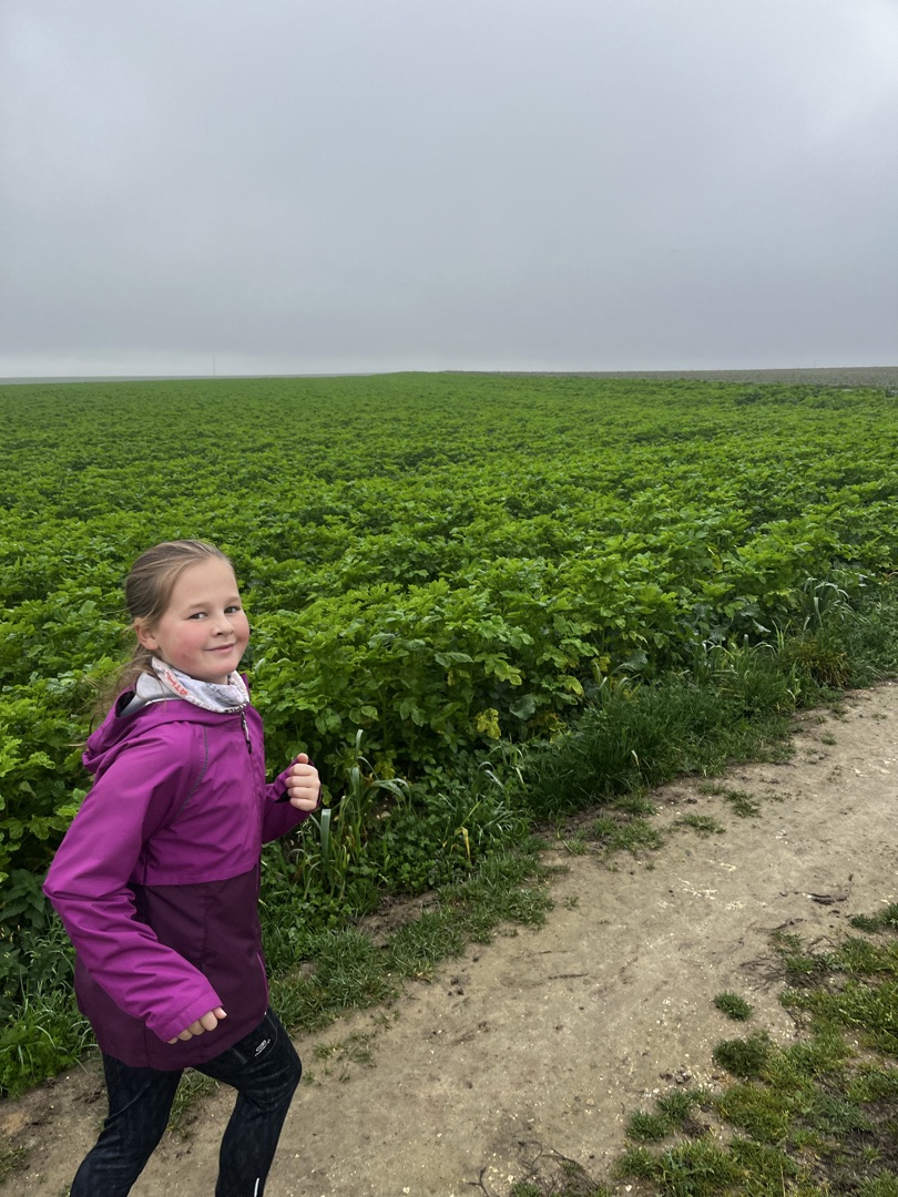 Agathe près d'un grand véhicule tout-terrain sur un sol volcanique.